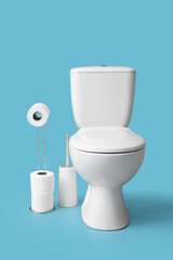 Holder with rolls of paper and toilet bowl on blue background