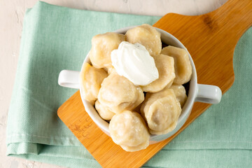 Appetizing homemade Russian dumplings served in a white cup. Top view.