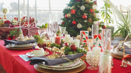 Christmas party table with Christmas tree and tableware and glasses