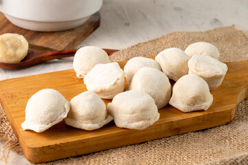 Fototapeta na wymiar Raw dumplings on a wooden board, light table.
