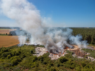 Aerial photo of garbage dump in fire in the countryside. Environmental pollution by burning different types of rubbish