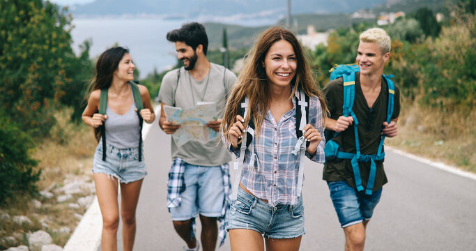 Group of friends with backpacks at summer outdoor. Travel concept