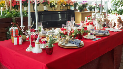 Christmas party table with Christmas present gift boxes and tableware and glasses	