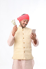 Young indian farmer using smartphone and showing money on white background.