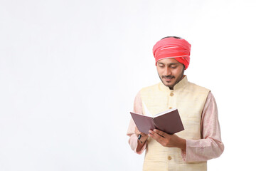 Indian farmer using diary on white background.