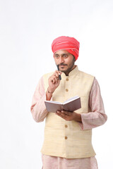 Indian farmer using diary on white background.