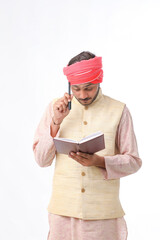 Indian farmer using diary on white background.