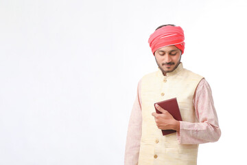 Indian farmer using diary on white background.