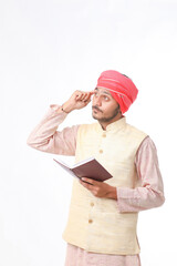 Indian farmer using diary on white background.
