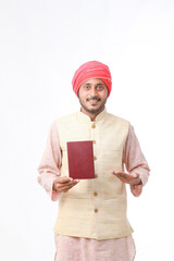 Indian farmer using diary on white background.