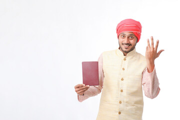 Indian farmer using diary on white background.