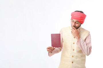 Indian farmer using diary on white background.