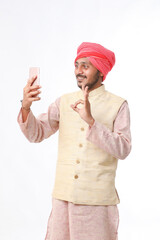 Young indian farmer using smartphone on white background.