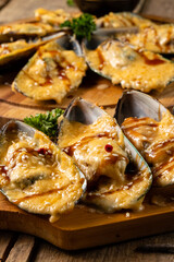 Mussels baked with cheese in shell halves, vertical photo, selective focus.