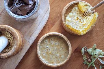 Top view of honey and powder ginger mixture for boosting immunity. Honeycomb in a wooden bowl on wooden table. Healty eating concept. Treatment for cough and sore throat.