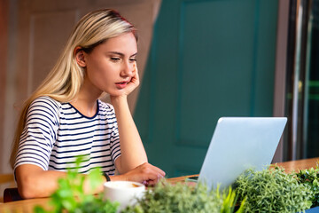 Concentrated at work. Beautiful woman working on laptop in creative office or cafe.