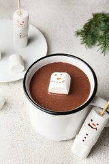 Cup of natural hot chocolate with marshmallows on light background