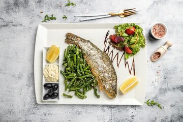 Fish dish roasted trout with parmesan, lemon and vegetables. Restaurant menu, dieting, cookbook recipe. top view