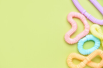 Different colorful Pop Tubes on green background