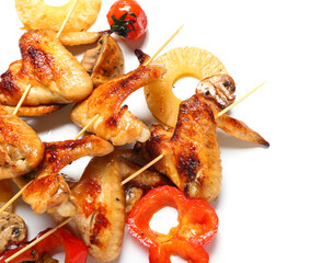 Grilled chicken wings skewers with vegetables on white background