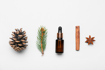 Fototapeta premium Natural essential oil dropper bottle with pine cone, fir branch, cinnamon stick, and star anise on white background
