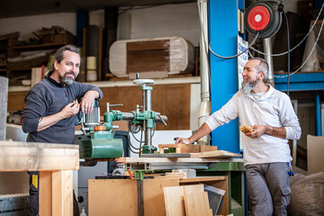 two craftsmen are taking a break in a workshop