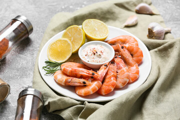Plate of tasty shrimps with sauce and lemon on table