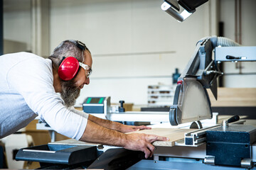 male craftsman saws wood on a circular saw