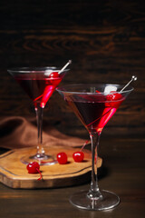 Glasses of tasty Manhattan cocktail on dark wooden background