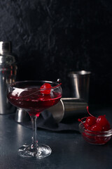 Glass of tasty Manhattan cocktail on black background