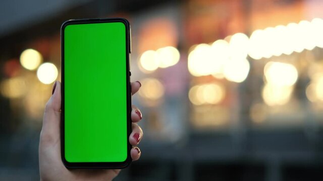 Point of View of voman at street Using Phone With Green Mock-up Screen Chroma Key Surfing Internet Watching Content Videos Blogs Tapping on Center Screen