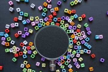 Choice and management concept. A magnifying glass on the black chalkboard surrounded by colorful...