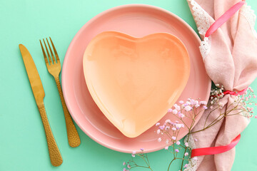 Beautiful table setting for Valentine's Day on green background