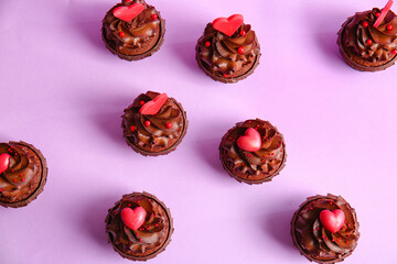 Tasty chocolate cupcakes for Valentine's day on purple background