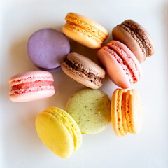 Colorful macaroons on the white background. Lemon yellow, strawberry pink and green french cookies. 