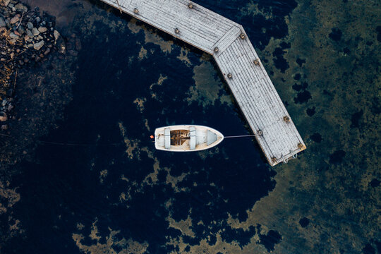 Altes Anglerboot in Schweden in einem abgelegenen See mit Holzsteg von oben fotografiert 