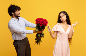 Unwanted confession. Displeased indian lady rejecting her admirer with roses on Valentine's Day,...