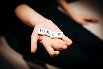 Fototapeta premium Girl asking for help. Girl stretches out her hands with the word help in the palms