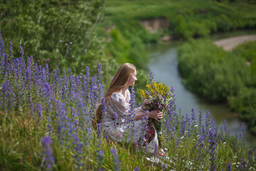 Medieval lady in historical dress. Aroma of spring nature, wild flowers, blue sky, sunshine.