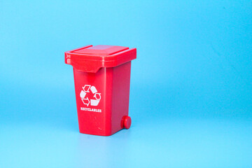 red recycling bins with a recycling logo and a blue background