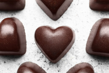 Tasty heart-shaped candies on light background, closeup