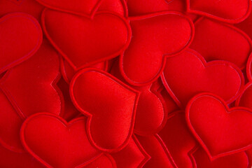 Bright festive background of red fabric hearts. A perfect composition for a gift on Valentine's Day, for a wedding, engagement, anniversary. Flat lay, top view, close-up