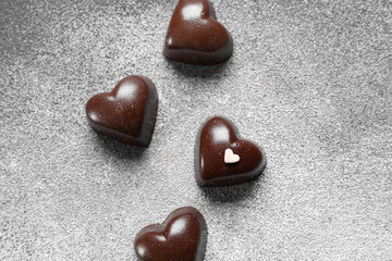 Tasty heart-shaped candies on grey background