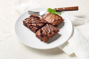 Plate with pieces of tasty chocolate brownie on white background