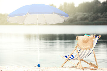 Vacation concept. Lounger and sunscreen umbrella at the beach. Empty seashore. Empty bay.