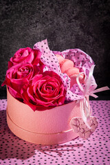 Red roses and pink macaroons in pink basket and pink heart. Background for valentines and woman day. Wedding decoration