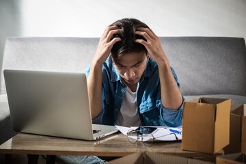 Serious upset young man entrepreneur at home works on a laptop computer and online checks no orders...