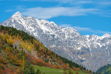Fototapeta premium Beautiful mountain landscape, sunny autumn day with colorful trees and impressive snow peaks. Picturesque landscapes of the Caucasus mountains, Svaneti, Georgia