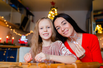 Fototapeta na wymiar Happy family mother and daughter bake cookies for Christmas