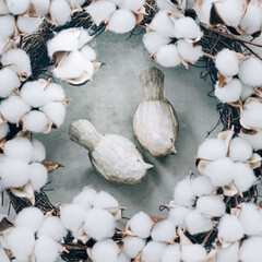 Decorative cotton flowers with two wooden birds. Nude tones, spring elements, square format.